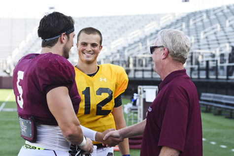 SIU’s Director of Broadcast Operations Mike Reis congratulates newly-crowned starting quarterback Josh Straughan alongside senior middle linebacker Chase Allen on Wednesday, Aug. 24, 2016, at Saluki Stadium. (Athena Chrysanthou | @Chrysant1Athena)