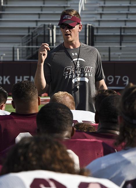 Head football coach Nick Hill debriefs with players after practice on Wednesday, Aug. 24, 2016, at Saluki Stadium. (Athena Chrysanthou | @Chrysant1Athena)