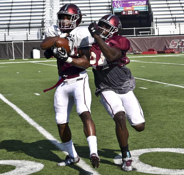 Sophomore wide receiver Jimmy Jones catches a pass alongside sophomore safety Jefferson Vea on Tuesday, Aug. 30, 2016, during practice at Saluki Stadium. (Autumn Suyko | @AutumnSuyko_DE)