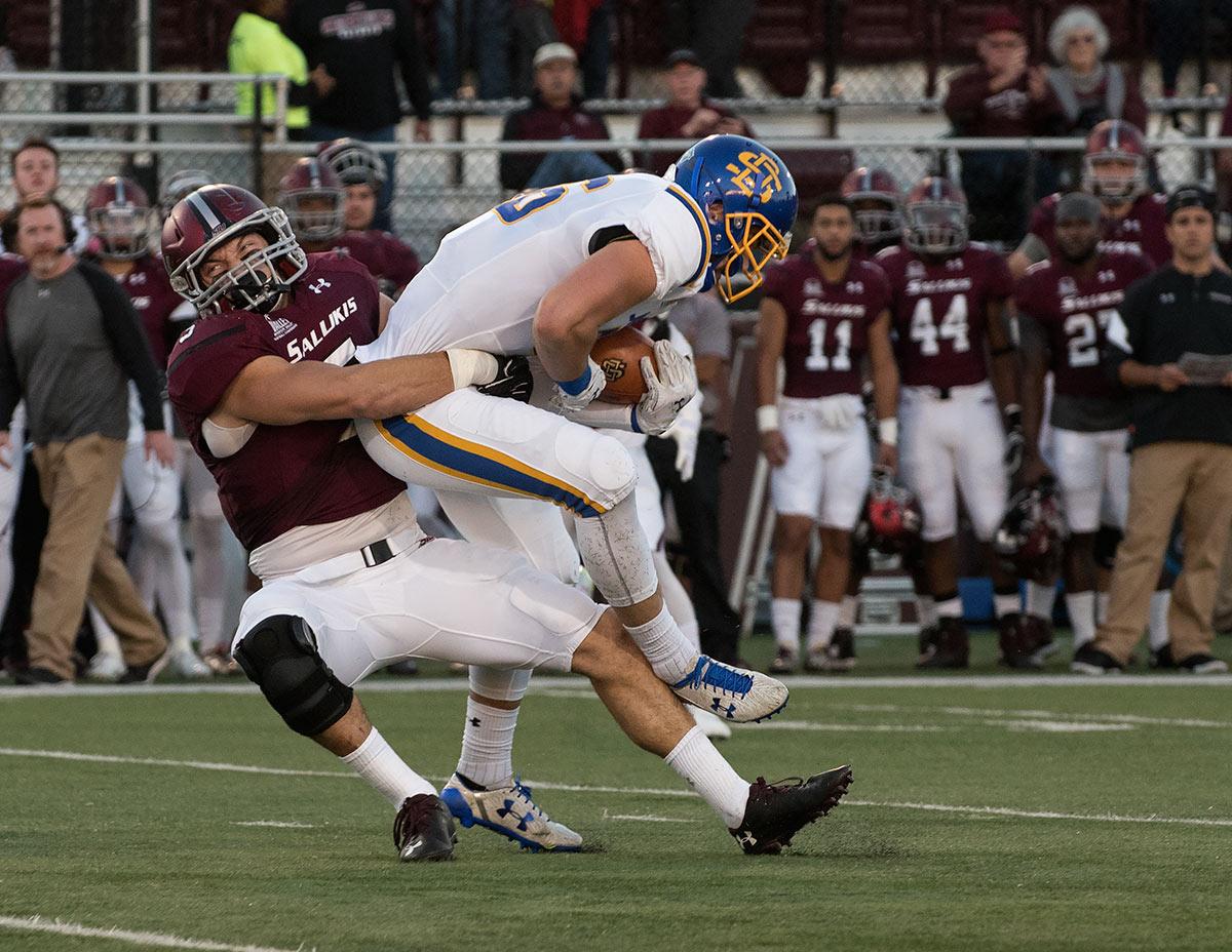 Saluki senior inside linebacker Chase Allen tackles Jackrabbit junior tight end Dallas Goedert during the first half of the SIU's 45-39 loss to South Dakota State on Saturday, Oct. 8, 2016, at Saluki Stadium. (Jacob Wiegand | @JacobWiegand_DE)