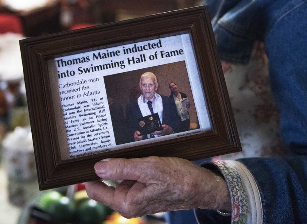 Shirley Maine holds a framed Carbondale Times article about her husband's induction into the International Masters Swimming Hall of Fame on Monday, Oct 17, 2016, in the couple's Carbondale home. (Morgan Timms | @Morgan_Timms)
