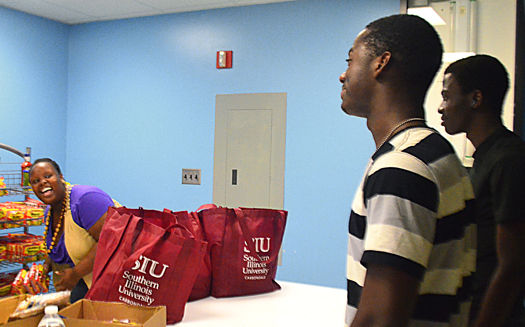 Nicanor Wolieu and Daniel Edi, both freshmen from Ivory Coast, West Africa, talk to Myah Gary, a sustainability worker at the food pantry held in the Student Center on campus Wednesday. The food pantry is part of SIU Sustainability. Students donated food during the move-out in May to redistribute to summer students. We hope this will be a recurring program, Gary said. It would be great for the program to grow.KETURAH TANNER • DAILY EGYPTIAN
