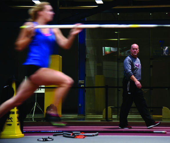 New track and field coach Terry VanLaningham watches junior pole-vaulter Katie Trupp approach a vault during practice Nov. 23, 2015. VanLaningham started at SIU this year coaching jumps, pole vault and multi-event athletes after 11 seasons at Sacramento State University. So far, he has found the transition pleasantly challenging. It takes time to be able to develop the relationship with each individual athlete, especially when you hit the ground running during a school year, VanLaningham said. It’s refreshing to be somewhere where everywhere you go people care about the university and care about the program. You don’t find that everywhere.