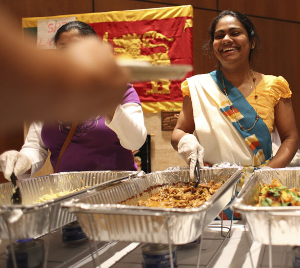 Chamila Ranaweera, a graduate student in mathematics from Sri Lanka, smiles while scooping out curry for attendees of the International Food Fair on Wednesday at the Student Center. Members from the Sri Lankan Student Association brought items from their homeland as well as food to help spread their culture. 