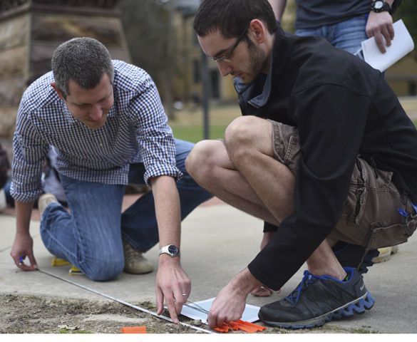 Nathan Meissner, left, an SIU graduate with his Ph.D. in archaeology, measures ground distance with Chad Hall, a senior from Decatur studying criminology and criminal justice, during an archeological site examination Tuesday at the site of the Old Main building. “We’ve done a couple limited tests with [the ground penetrating radar], but this is the largest run,” said Meissner, a current research associate. “It’s a learning experience for us.  An amazing thing would be to use this equipment full scale at a large prehistoric site here in southern Illinois. I like using high tech equipment, it bring out the inner nerd in me.”
