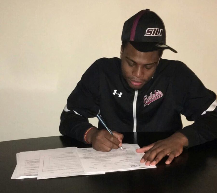 Incoming+Saluki+freshman+guard+Jeremy+Roscoe+signs+his+letter+of+intent+to+attend+SIU.+The+6-foot-3+guard+won+the+2014+IHSA+Class+2A+state+championship+at+Uplift+Community+High+School.