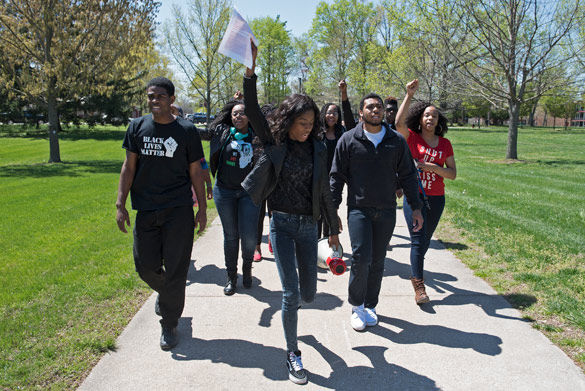 Leilani Bartlett, middle with papers, a freshman from Chicago studying business, leads a march April 12 from Brown Hall to Morris Library. Bartlett, who organized the event, posted a video to Facebook on April 4 expressing her concerns about racism she said she has experienced at SIU. Her video received over 161,000 views. (Jacob Wiegand | @JacobWiegand_DE)