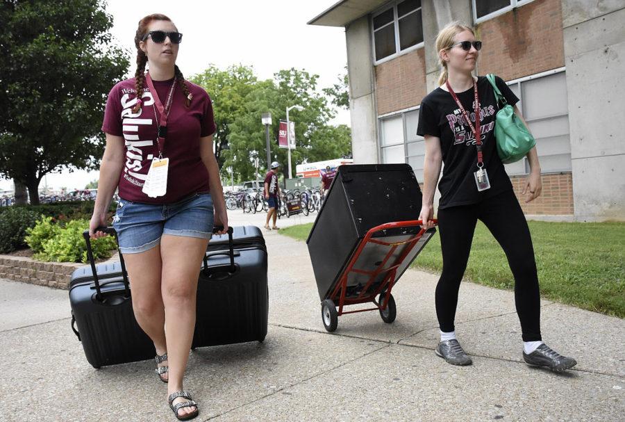 Emmalie Hall, a junior from Chicago studying interior design, moves her belongings with the help of volunteer Desiree Smith on Friday outside Mae Smith Hall. (Athena Chrysanthou | @Chrysant1Athena)