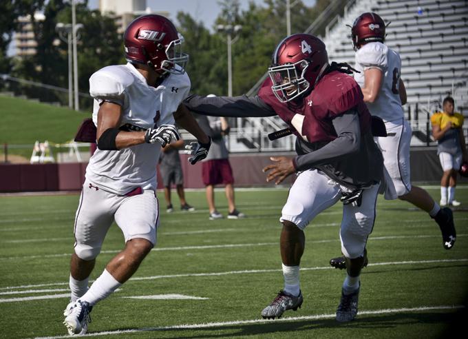 Senior wide receiver Israel Lamprakes sprints to catch a pass while being defended by junior cornerback Roman Tatum on Tuesday, Aug. 30, 2016, during practice at Saluki Stadium. (Autumn Suyko | @AutumnSuyko_DE)