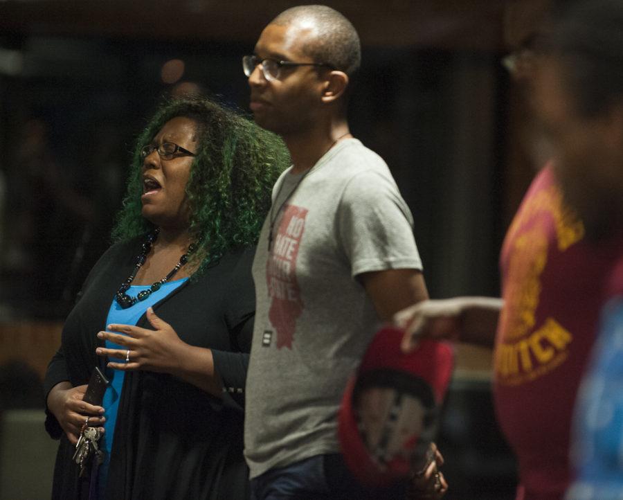 Surrounded by students, faculty and community members, Kayce Gibbs, left, a graduate student studying public administration, sings a hymn, Wednesday, Aug. 31, 2016, during a vigil for the Orlando shooting victims in Grinnell Hall. Gibbs is the vice president of the campus gospel choir and sings at Hopewell Missionary Baptist Church. (Ryan Michalesko | @photosbylesko)