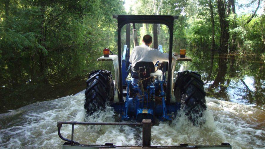 David Lester drives a tractor through a flooded street in Breaux Bridge, La. (Molly Hennessy-Fiske/Los Angeles Times/TNS)