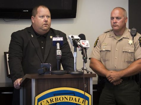 Carbondale Police Chief Jeff Grubbs speaks to reporters Monday afternoon about the shooting of a Carbondale police officer while Illinois State Police District 13 commander William D. Sons looks on at the Carbondale Public Safety building. (Isabel Miller for the Daily Egyptian)