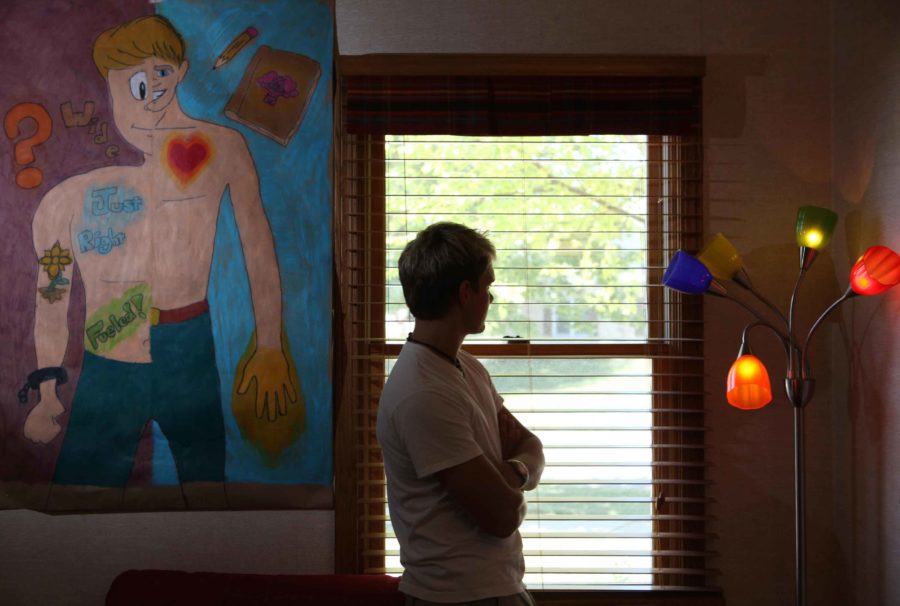 Rob stands next to a self-portrait or a body trace where one side depicts reality and the other side depicts perception, June 26, 2012, in Elgin, Illinois. He made this artwork while at Roger Memorial Hospital where he was being treated for an eating disorder in 2011. (Stacey Wescott/Chicago Tribune/MCT)