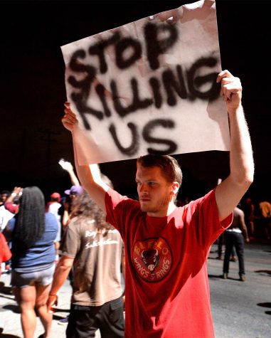 A protestor carries a sign along Old Concord Rd. on Tuesday night, Sept. 20, 2016 in Charlotte, N.C. The protest began on Old Concord Road at Bonnie Lane, where a Charlotte-Mecklenburg police officer fatally shot a man in the parking lot of The Village at College Downs apartment complex Tuesday afternoon. The man who died was identified late Tuesday as Keith Scott, 43, and the officer who fired the fatal shot was CMPD Officer Brentley Vinson. (Jeff Siner/Charlotte Observer/TNS)