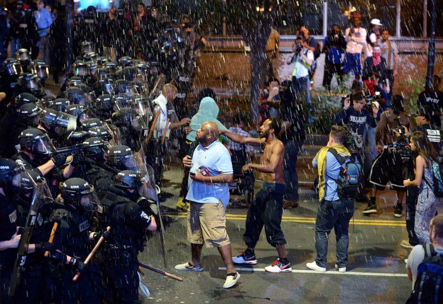 Debris falls upon Charlotte officers and protestors as officers began to push protestors from the intersection near the Epicentre Wednesday, Sept. 21, 2016 in Charlotte, N.C. The protestors were rallying against the fatal shooting of Keith Lamont Scott by police on Tuesday evening in the University City area. (Jeff Siner/Charlotte Observer/TNS)