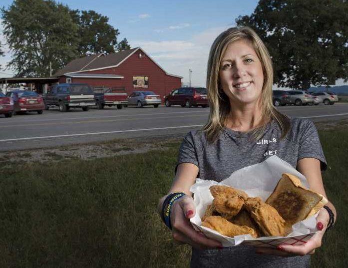 Kristi Thies, owner of Bottoms Up Bar & Grill, poses for a portrait with a basket of fried chicken Wednesday, Oct. 5, 2016, in Jacob. Kristi and her husband, Jason, have owned Bottoms Up since 2009. Located on Neunert Road in Jacob, the bar and grill serves half and whole fried chickens on Wednesday nights. (Ryan Michalesko | @photosbylesko)