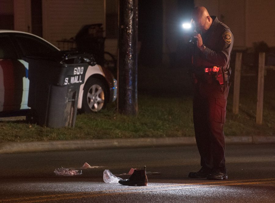 Officer Zach Street, a crash reconstructionist for the Carbondale Police Department, takes a picture of a shoe after a pedestrian was hit by a car Saturday, Oct. 15, 2016, in the 600 block of South Wall Street in Carbondale. (Jacob Wiegand | @JacobWiegand_DE)