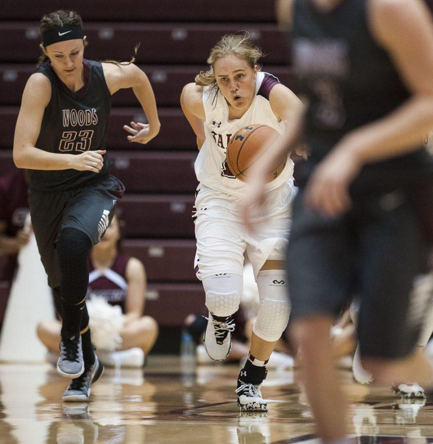 Freshman forward Caitlyn Claussen (15) makes a break past William Woods freshman guard Peyton Greenlee (23) during the Salukis 78-58 win over the William Woods Owls on Thursday, Oct. 27, 2016, at the SIU Arena. (Ryan Michalesko | @photosbylesko)