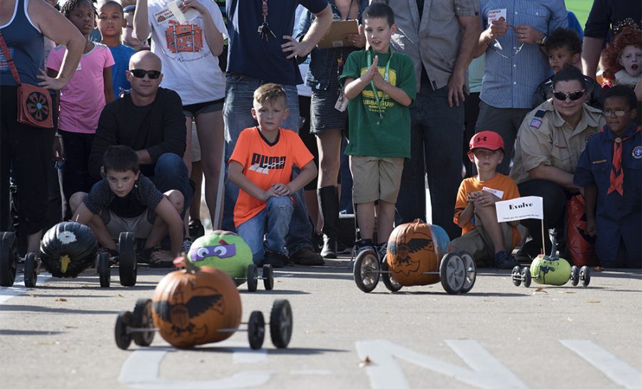 Children watch as their pumpkins race down Mill Street during the the Great Carbondale Pumpkin Race on Saturday, Oct. 29, 2016, near the intersection of Mill Street and South Illinois Avenue. (Morgan Timms | @Morgan_Timms) 