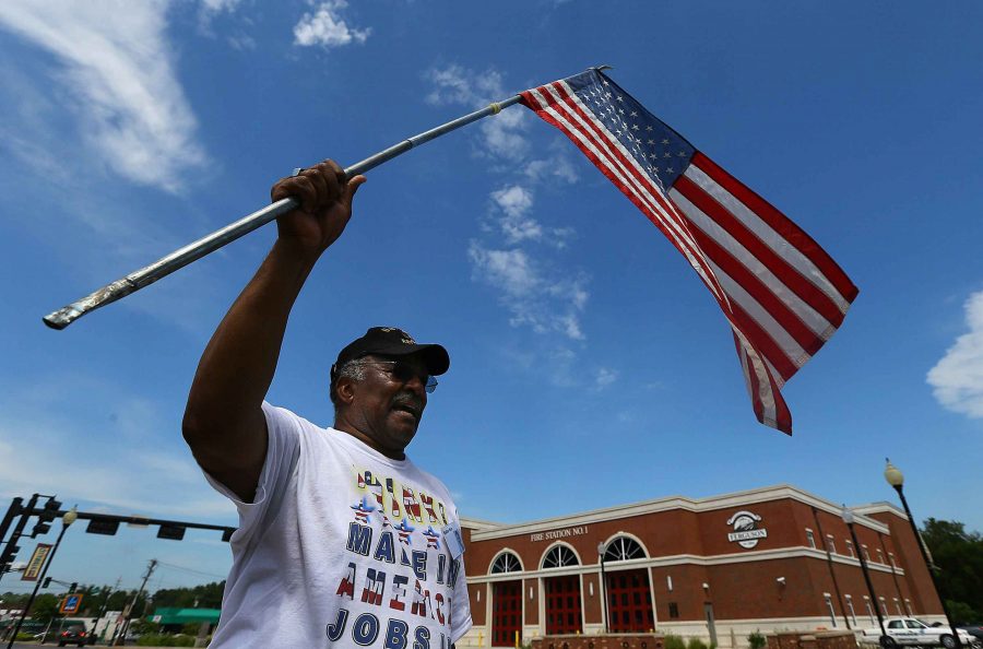 Protester Walter Rice, 75, a life-long Ferguson resident and Vietnam veteran waves, a U.S. flag in front of the Ferguson police department on Tuesday, Aug. 19, 2014, in Ferguson, Mo. (Curtis Compton/Atlanta Journal-Constitution/MCT)