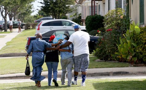 Monique Morgan, the mother of Carnell Snell, is escorted home by neighbors after viewing a makeshift memorial for her son on Sunday morning, Oct. 2, 2016. Snell, 18, was shot and killed by the Los Angeles Police Department officers after a brief car chase that ended near the intersection of 107th Street and Western Avenue in South Los Angeles on Saturday. Police suspected Snell was driving a stolen vehicle and claimed a weapon was found at the scene. (Luis Sinco/Los Angeles Times/TNS)