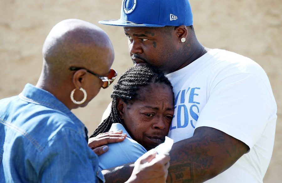 Monique Morgan, the mother of Carnell Snell, is held by a neighbor as they stand beside a makeshift memorial for Morgans son Sunday morning, Oct. 2, 2016. (Luis Sinco/Los Angeles Times/TNS)