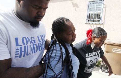 Neighbors brace a distraught Monique Morgan, center, as she visits the scene of an officer-involved shooting in South Los Angeles, Calif. where her son Carnell Snell Jr., 18, was killed. (Luis Sinco/Los Angeles Times/TNS)
