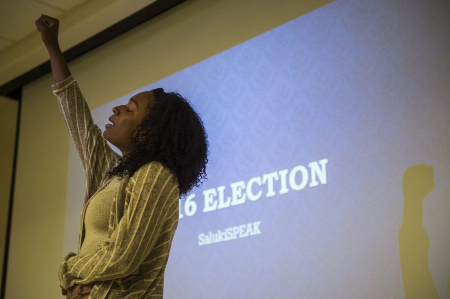 ReJean Pink, a freshman from Chicago studying English, raises her fist while reciting a poem Tuesday, Nov. 1, 2016, during a Salukis SPEAK poetry slam at the Student Services Building. I like that I get to hear what other people have to say, Pink said of the event. Salukis SPEAK have two more forums planned for this month. (Ryan Michalesko | @photosbylesko)