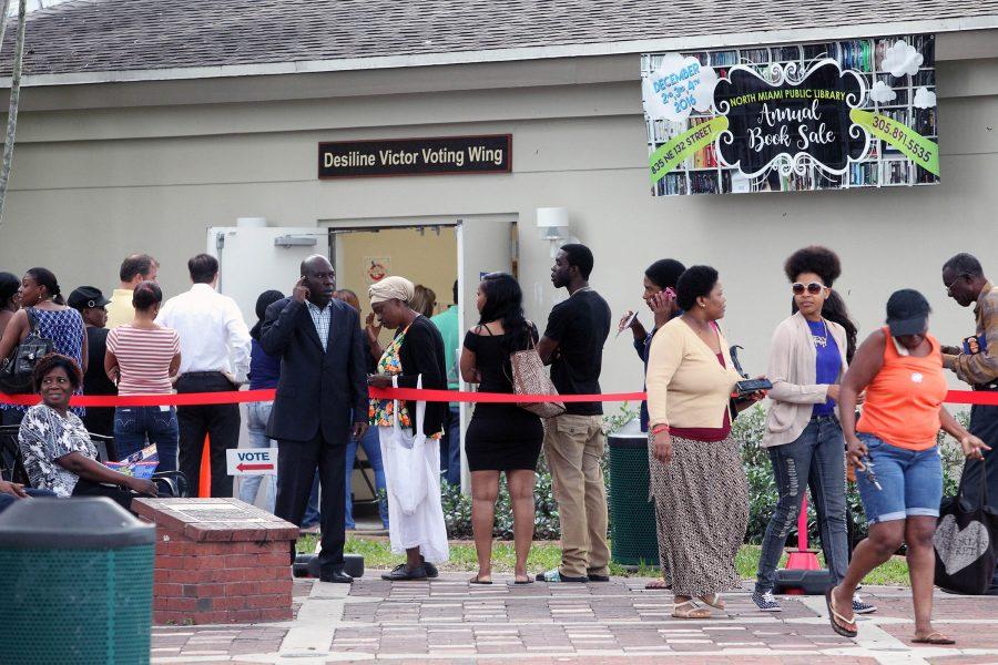 A group of people stand in line waiting to vote early outside the North Miami Public Library on Friday, Nov. 4, 2016. (Roberto Koltun/Miami Herald/TNS)