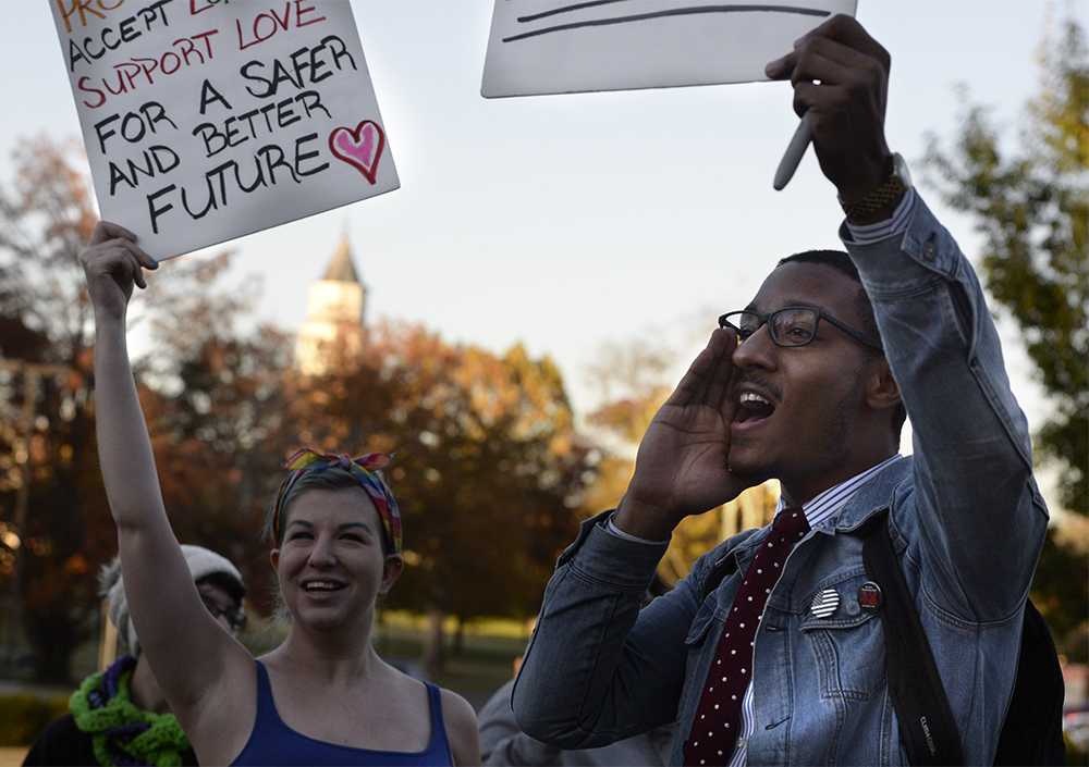 Michael Smith, a senior from Chicago studying political science, leads a chant Wednesday, Nov. 16, 2016, as demonstrators protest in front of Morris Library. (Bill Lukitsch | @lukitsbill)