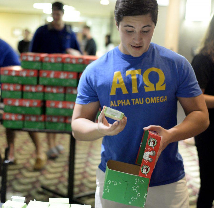 Daniel Bello, a sophomore from Algonquin studying marketing, packs a shoebox with presents Thursday, Nov. 17, 2016, in the Student Centers Old Main room. Bello participated in the charity event Operation Christmas Child, a gift-giving initiative sponsored by the universitys chapter of Alpha Tau Omega. (Bill Lukitsch | @lukitsbill)  