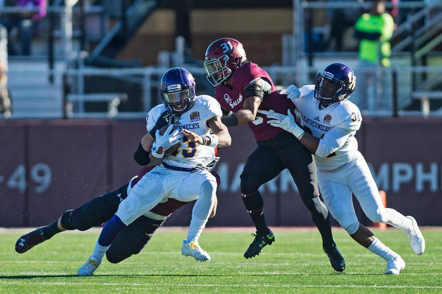 Saluki senior inside linebacker Chase Allen (5) tackles Leatherneck sophomore wide receiver Stacey Smith (13) as junior cornerback Craig James (31) and sophomore running back Steve McShane (34) close in on the pair during the first half of the SIUs matchup against WIU on Saturday, Nov. 19, 2016, at Saluki Stadium. (Jacob Wiegand | @jawiegandphoto)