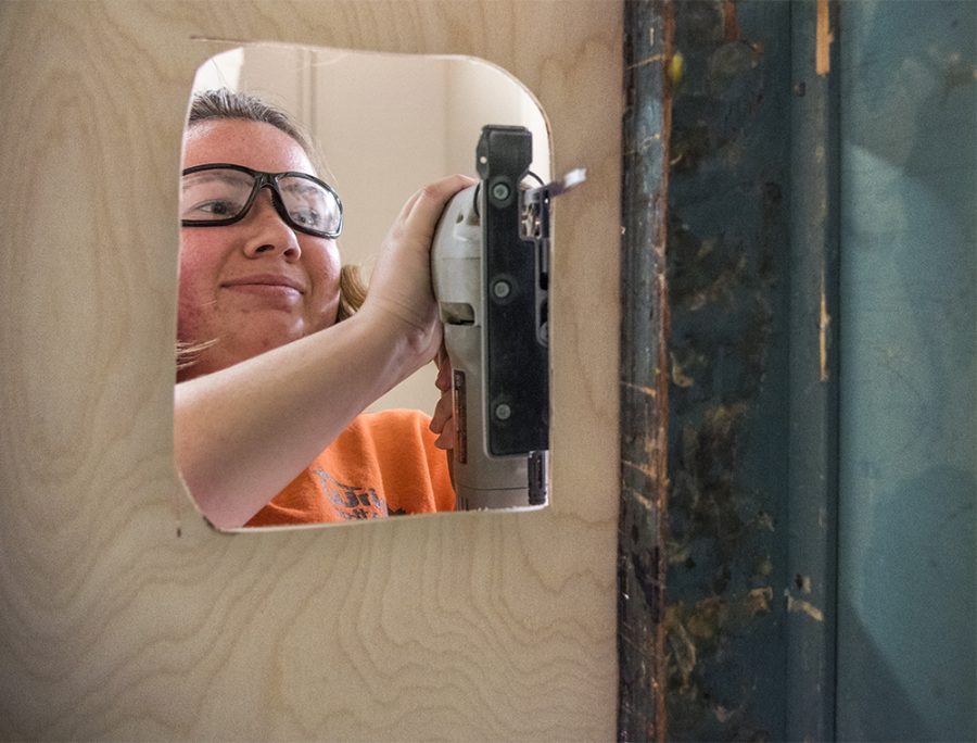 Caroline Simmons, a senior from Port Byron studying architecture, uses a jig saw to cut out a space for outlets in the new lactation stations interior panels Tuesday, Dec. 6, 2016, during an independent study class in the woodshop of Quigley Hall.