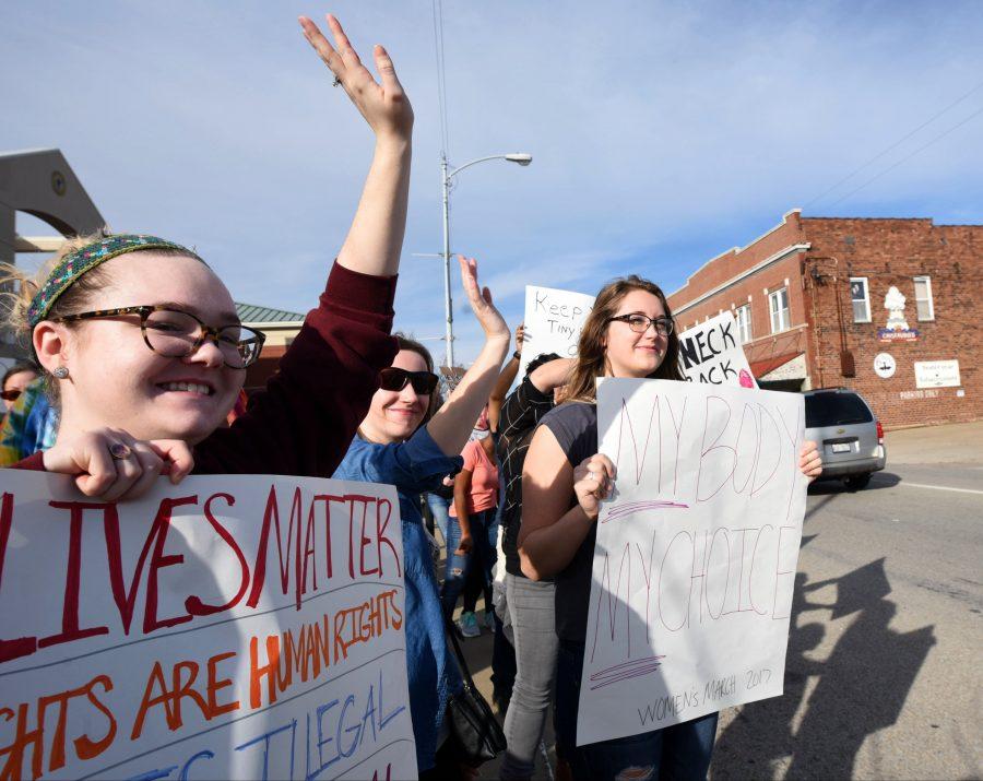 Demonstrators participating in the Southern Illinois Women’s March wave to passing cars on Saturday, Jan. 21, 2017, in front of the Carbondale Civic Center. (Bill Lukitsch | @lukitsbill) 