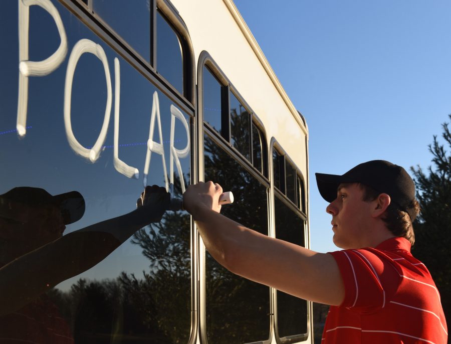 Jakob Guetersloh writes Polar Express on the side of his bus Tuesday, Jan. 24, 2017, in the driveway of his Murphysboro home. The 19-year-old is owner of At Your Service, a party bus company that specializes in tours along the Shawnee Wine Trail.  Guetersloh, a second-year student at John A. Logan College, bought the bus in November 2015 with the intention of doing tours, and offered a special deal during Polar Bear weekend, an annual party for SIU students, that jump-started the small business. He gave rides to people on the street who flagged him down for $1 apiece. The teenage business-owner said that he wanted to make sure no one mistook him for the Saluki Bus — an error some made in January 2016.  “They were asking me where the swiping thing was and told them ‘It’s a dollar,’ he said. “It was just kind of funny though because they were so confused. (Bill Lukitsch | @lukitsbill)
