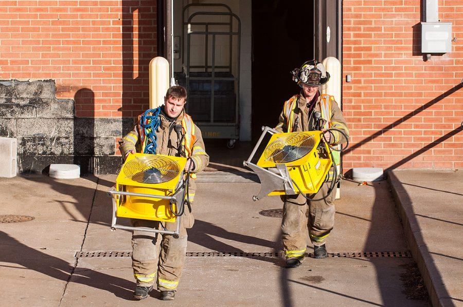 Zach Miller and Ryan Hall, of the Carbondale Fire Department, carry ventilation fans Friday, Feb. 3, 2017, out of the Memorial Hospital of Carbondale. (Jacob Wiegand | @jawiegandphoto)