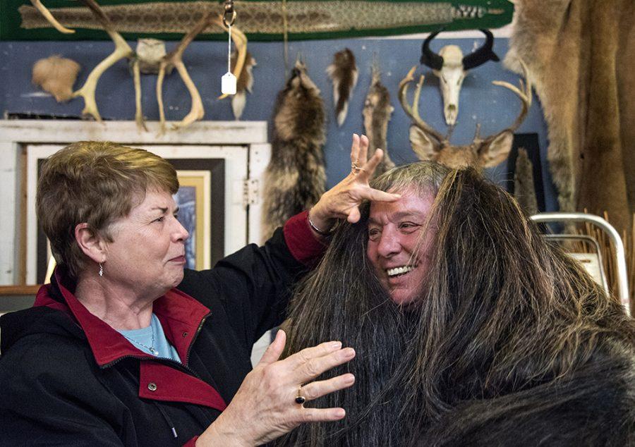 Barbara Cosgrove, of Murphysboro, brushes hair away from the face of George McNeal, of Murphysboro, as he tries on a cloak made from the wool of a musk ox Feb. 8 at George’s Resale and Antiques, the used furniture store he owns in Murphysboro. Cosgrove said she tries to visit the family-run store at least once a week. “George is really good about offering everyone a fair price,” Cosgrove said. “They’re such a nice family. And everybody loves George.” McNeal began George’s Resale and Antiques 23 years ago. 