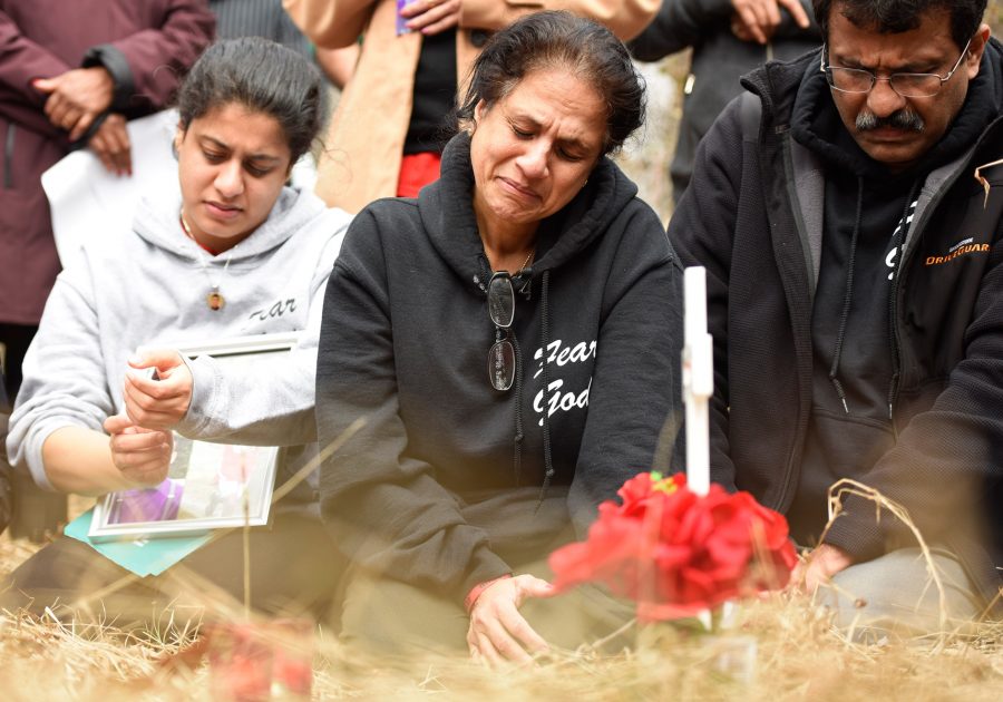 Pravin Varugheses older sister Priya, his mother Lovely, and his father Mathew kneel during a memorial ceremony on Saturday, Feb. 13, 2017, in the woods bordering Illinois Route 13, where police say he died of hypothermia about three years ago. (Luke Nozicka | @lukenozicka)