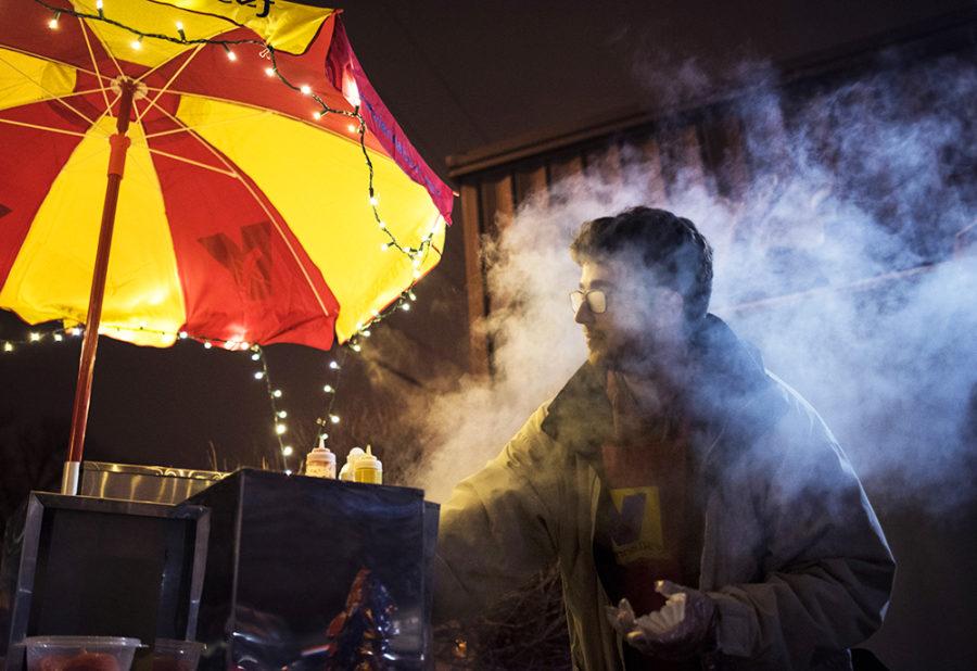 Chris Weatherwax, co-owner of Saluki Dawgs, battles the steam escaping from inside his hot dog cooker while preparing one of his specialty hot dogs for a customer Saturday, Feb. 18, 2017, by Pagliais Pizza on the Strip. Weatherwax and his friend Thomas Becker began the business in December and serve customers between 11 p.m. and 2:30 a.m. Fridays and Saturdays. Weatherwax credits Saluki Ventures, part of the Office of Economic and Regional Development, with helping them start and maintain their business. Honestly, we wouldnt be doing this if it werent for them, Weatherwax said. As far as getting locations, working with us to find out where we can go, who to talk to, theyve been so helpful. (Morgan Timms | @Morgan_Timms)