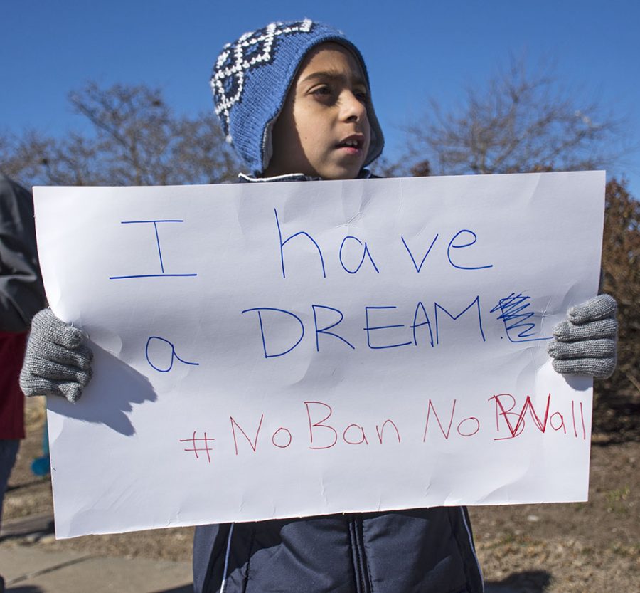 Alihadi Srour, 8, of Carbondale, holds a sign during the Peace Coalition of Southern Illinois monthly vigil Saturday, Feb. 4, 2017, on East Main Street. Srour was born in the United States and his mother, Nour Srour, was born in Lebanon. Nour believes President Donald Trump uses language that separates people based on their religion instead of uniting them. “I witnessed four wars when I was growing up and I dont want my kids to see that horror in their life, no matter where they are living,” Nour said. “I dont want them to grow up and feel scared to show who they are or where they are from.” (Athena Chrysanthou | @Chrysant1Athena)
