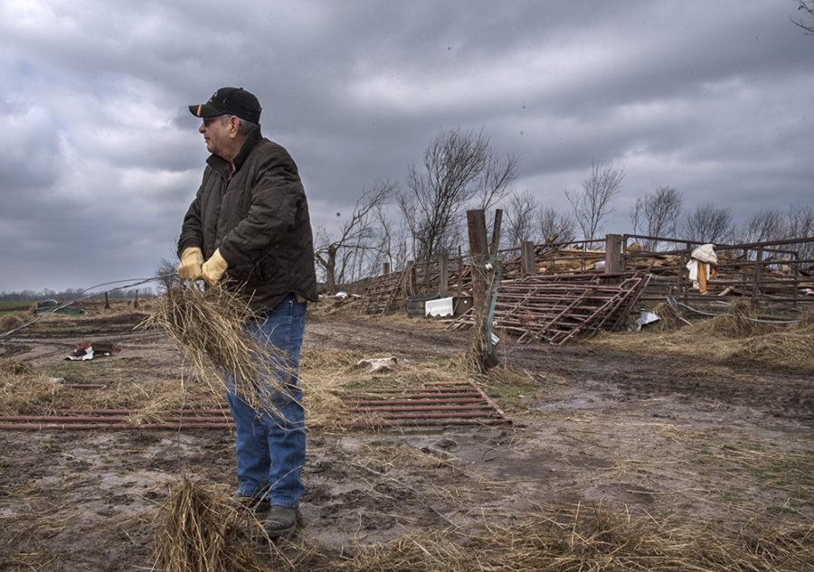 Joker Young, of Carbondale, surveys Oren Coffers horse and cattle farm as he detangles strands of hay from a wire fence Wednesday, March 1, 2017, while helping Coffer rebuild his property after Tuesdays tornado off Elkville Road in Vergennes. The tornado levelled Coffers 101-year-old barn and numerous other structures on his property. Its a miracle, Coffer said. Looking at this place, with all the damage, its a miracle nobody was hurt. 