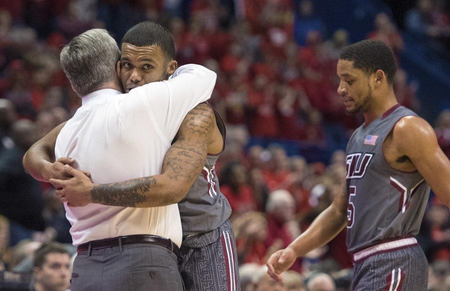 Coach Barry Hinson hugs senior guard Mike Rodriguez as he and fellow senior guard Leo Vincent walk off the floor for the last time in their Saluki careers Saturday, March 4, 2017, during SIU’s 63-50 loss to Illinois State in the Missouri Valley Conference men’s basketball tournament semifinals at Scottrade Center in St. Louis. (Sean Carley | @SeanMCarley)