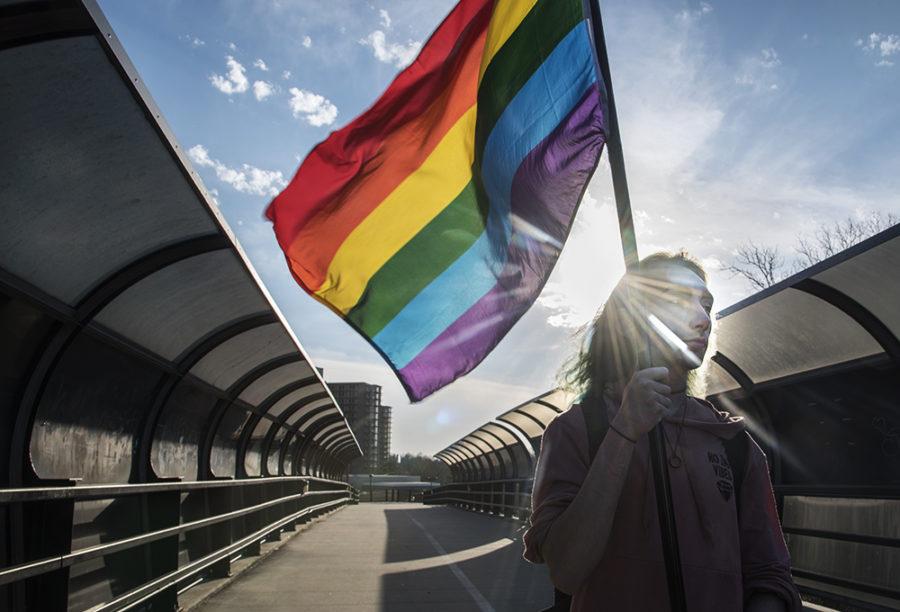 Michael Thornton, a freshman from Naperville studying digital media arts and animation, carries an LGBTQ flag while crossing the pedestrian bridge Monday, March 20, 2017, en route to an astronomy class in Carbondale. Since President Donald Trumps inauguration, Thornton described receiving both positive and negative responses. I was in the library one day and this complete stranger came up to me and hes like, Hey Ive seen you around with the pride flag. I really love what youre doing and its really made a difference for me, and he gave me a cookie. Moments like that happen often enough for me to feel like Im making a difference for other people. (Morgan Timms | @Morgan_Timms)