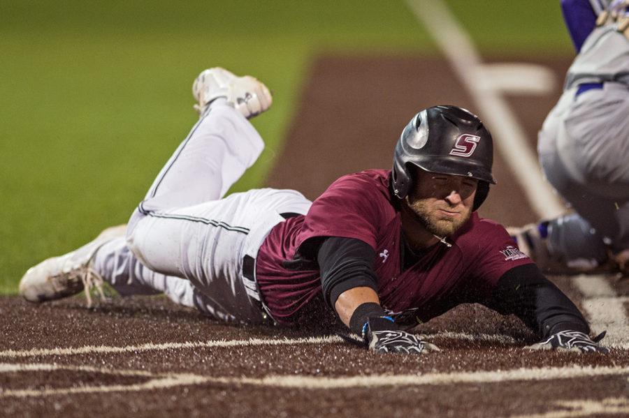 Junior infielder Hunter Anderson scores a run by sliding into home during SIU’s 3-2 win against the Evansville Purple Aces on Friday, March 31, 2017, at Itchy Jones Stadium. Anderson scored two runs during the game. (Jacob Wiegand | @jawiegandphoto) 
