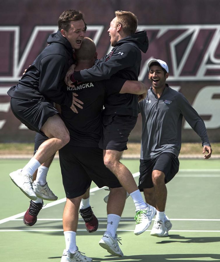 Members of the Saluki men’s tennis team congratulate junior Michal Kianicka after he clinched the last home match in Saluki mens tennis history Saturday, April 1, 2017, at University Courts. (Athena Chrysanthou | @Chrysant1Athena)
