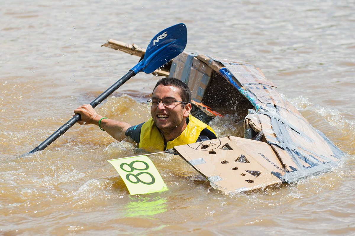 Aidan Ali, of Carbondale, falls into the water after the capsizing of his boat, The Robbie Shae, on Saturday, May 6, 2017, during the 44th Annual Great Cardboard Boat Regatta at Evergreen Park in Carbondale. The boat capsized seconds after the start of the race. (Jacob Wiegand | @jawiegandphoto)
