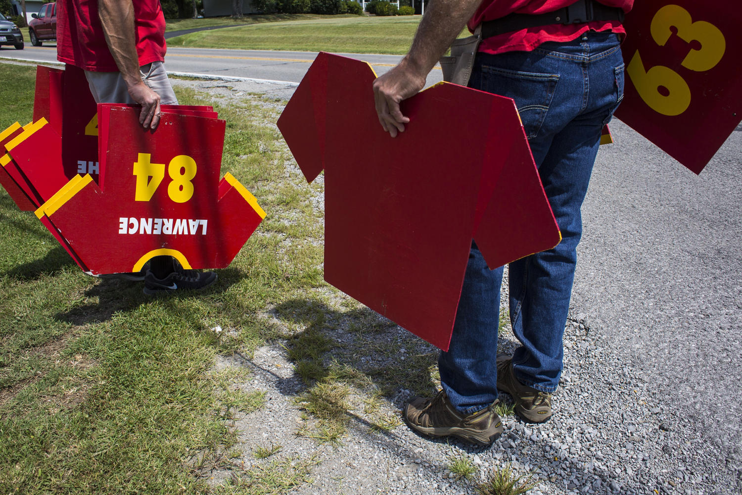 Grant Guthman, left, and Mike Karg, both of Murphysboro, hang Red Devils football jersey signs along North 14th Street prior to the 100th meeting between the Murphysboro Red Devils and the Carbondale Terriers on Friday, Aug. 25, 2017, in Murphysboro, Illinois. (Ryan Michalesko | @photosbylesko)
