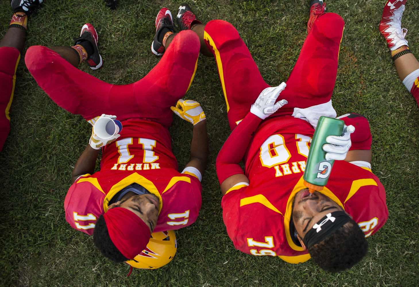 Murphysboro quarterback Gavin Topp, left, and outside linebacker Mo Valliant rest prior to kickoff of the 100th meeting between the Murphysboro Red Devils and the Carbondale Terriers on Friday, Aug. 25, 2017, at Doc Bencini Field, in Murphysboro, Illinois. (Ryan Michalesko | @photosbylesko)