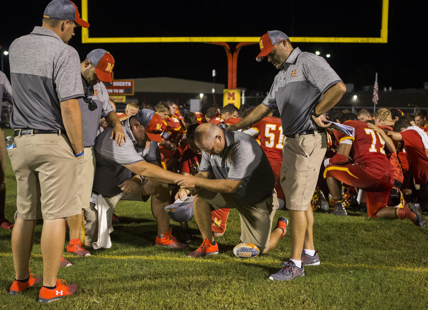 The Red Devils coaching staff prays together after losing to the Carbondale Terriers in the the 100th meeting of the two teams on Friday, Aug. 25, 2017, at Doc Bencini Field, in Murphysboro, Illinois. (Ryan Michalesko | @photosbylesko)