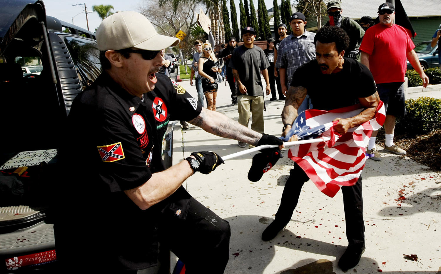 A Ku Klux Klansman, William Hagen, left, fights a counterprotester for an American flag after members of the KKK tried to start a White Lives Matter rally on Feb. 27, 2016 at Pearson Park in Anaheim, Calif. California might not seem an ideal place for the extreme-right and white-nationalist groups to make a stand. But the movement has increasingly targeted the state in recent years. (Luis Sinco/Los Angeles Times/TNS)